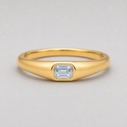 3D render of a polished yellow gold ring featuring a rectangular emerald-cut white sapphire in a bezel setting, shown on a neutral light grey background.