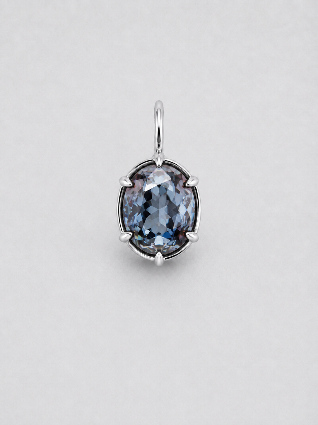 A 3D render of an oval-cut colour change sapphire pendant in a gold multi claw setting with a matching gold bail, shown on a neutral light grey background.