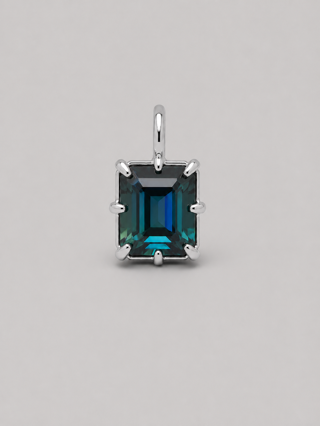 3D render of an emerald cut blue/green parti sapphire on a silver multi claw setting