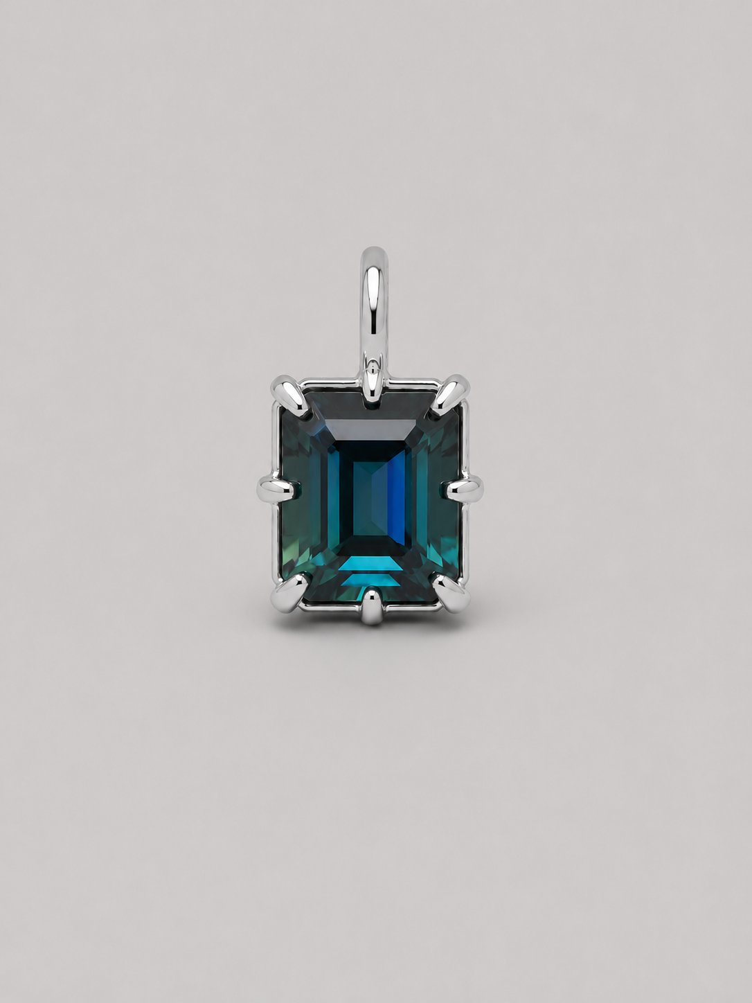 3D render of an emerald cut blue/green parti sapphire on a silver multi claw setting