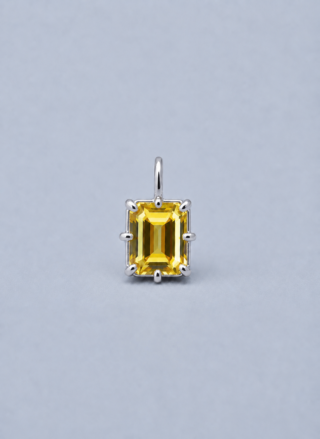 3D render of an emerald cut yellow Australian sapphire in a silver multi claw pendant setting 