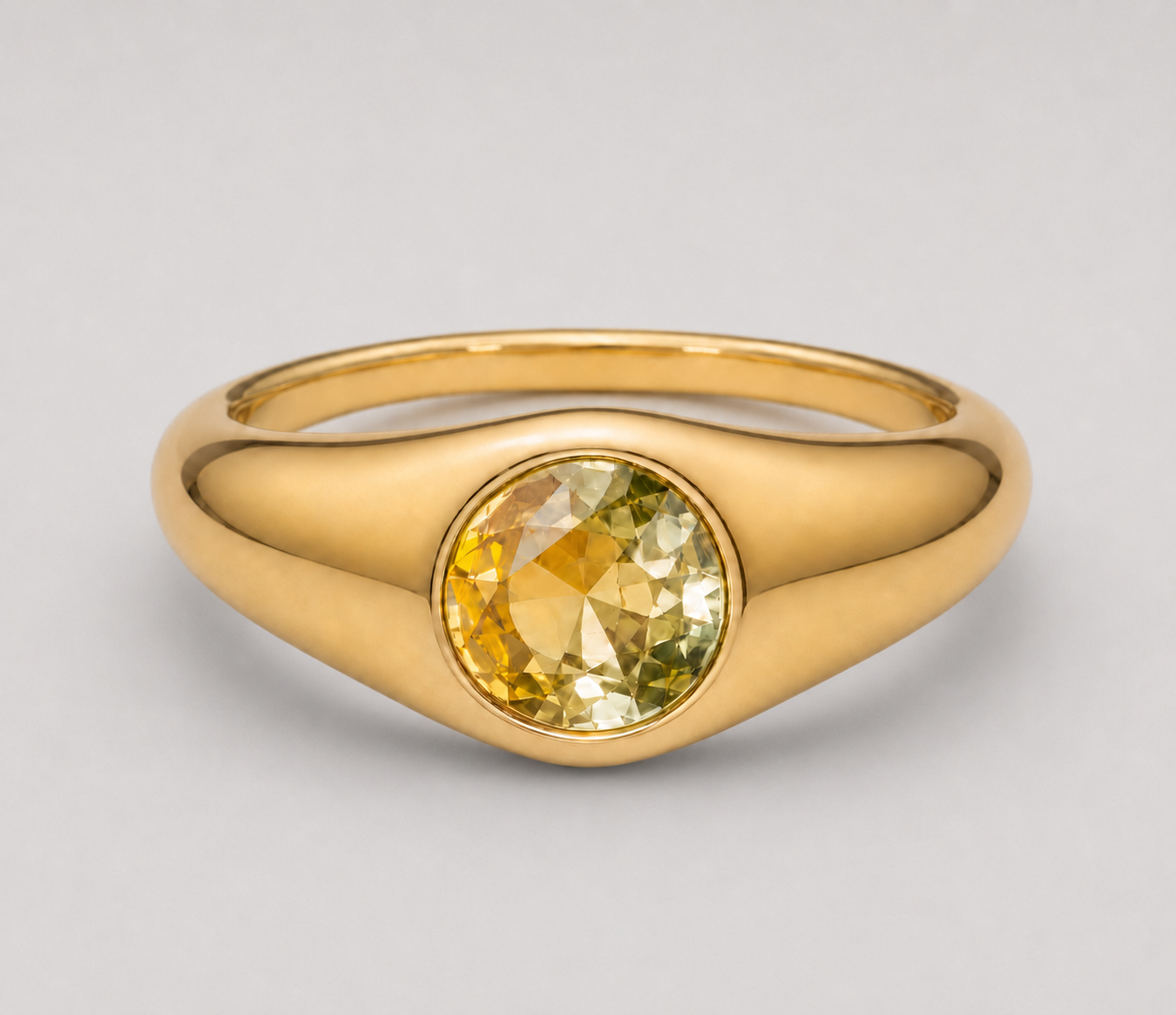 3D render of a signet style bezel set ring with a round bi-coloured yellow sapphire in yellow gold