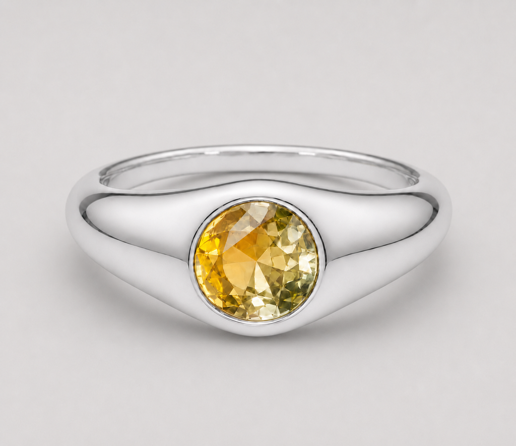 3D render of a signet style bezel set ring with a round bi-coloured yellow sapphire in sterling silver