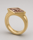 3D render of a lozenge dusty pink zircon in a yellow gold signet style ring