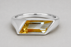 3D render of a silver signet ring with a bi-coloured rhombus shaped citrine on a white background