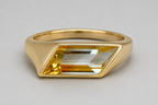 3D render of a gold signet ring with a bi-coloured rhombus shaped citrine on a white background