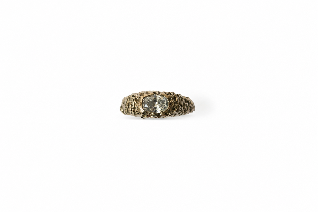 textured gold ring with a white diamond on a white background