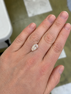 Golden rutilated white topaz loose pear shape stone on a persons hand for scale