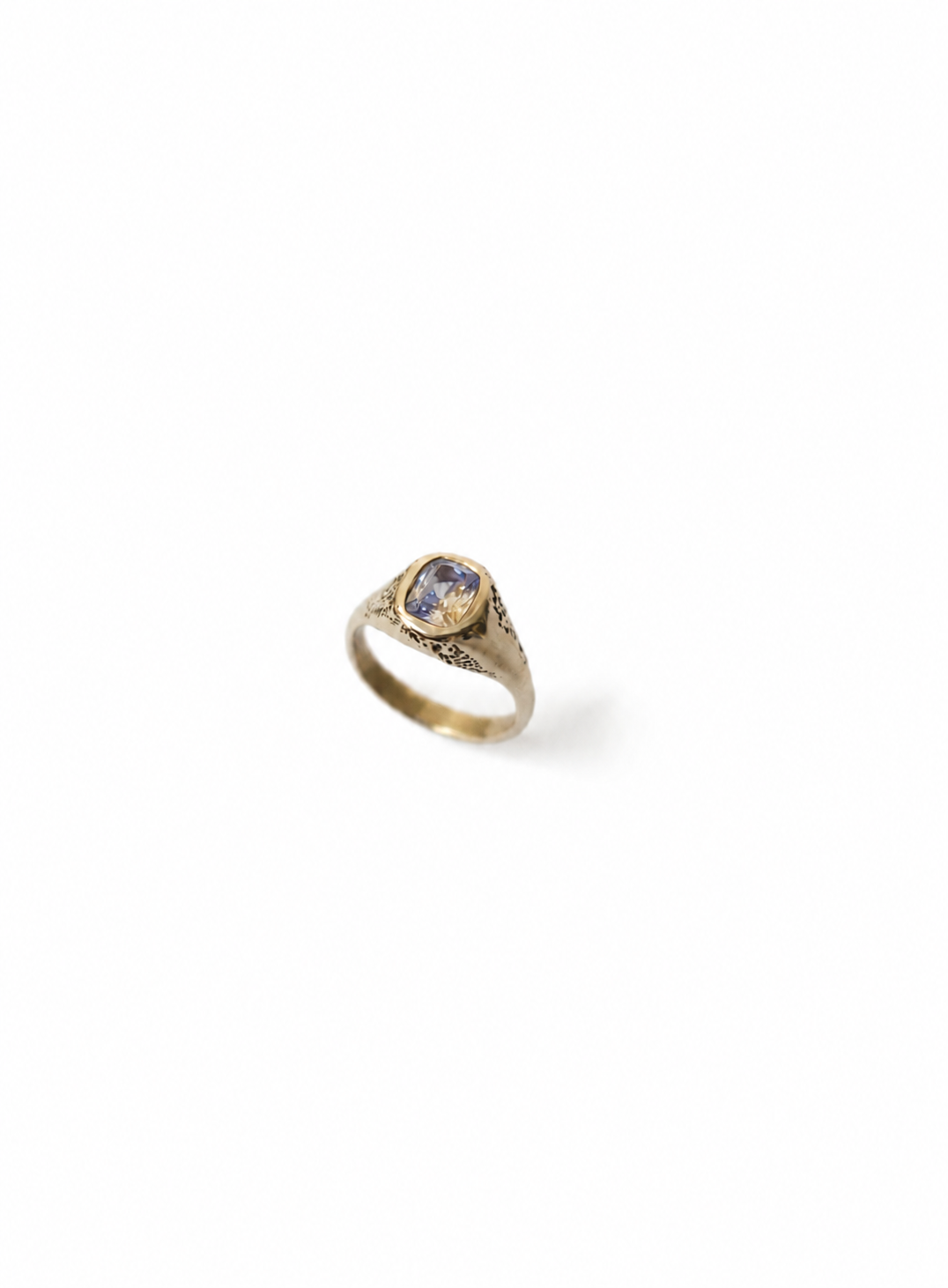 Gold signet ring with a parti sapphire on a white background