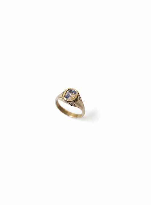 Gold signet ring with a parti sapphire on a white background