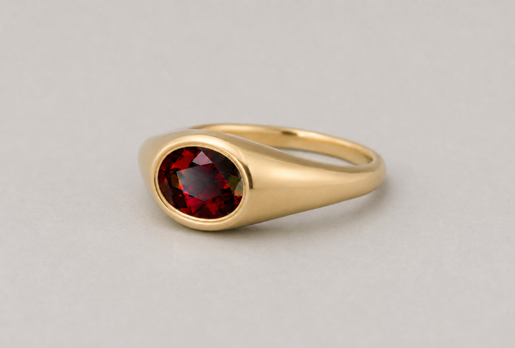 3D render of a deep red almandine garnet bezel set in a yellow gold signet ring
