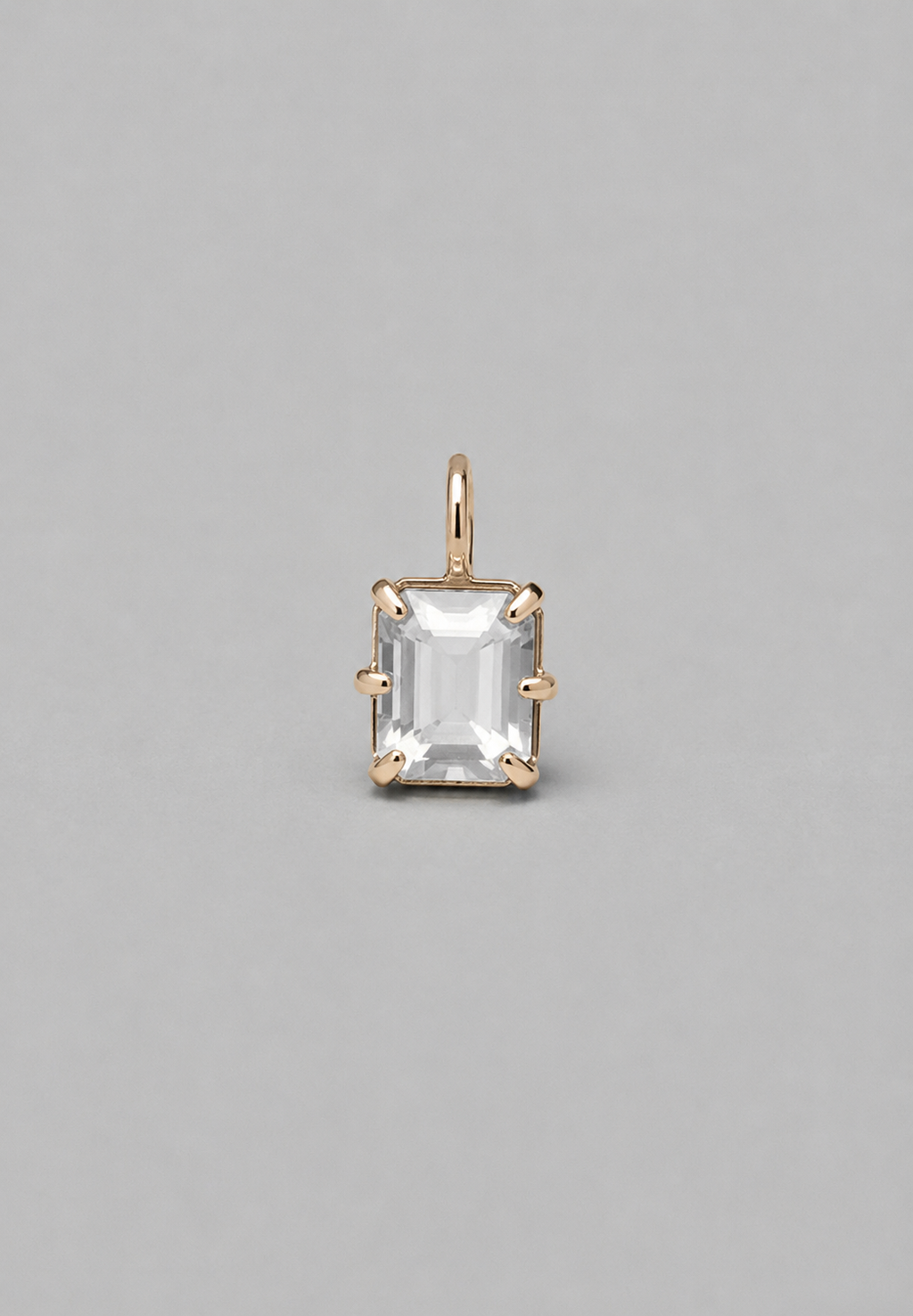 3D render of emerald-cut milky white sapphire pendant in a gold  in a multi claw setting on a solid grey background.