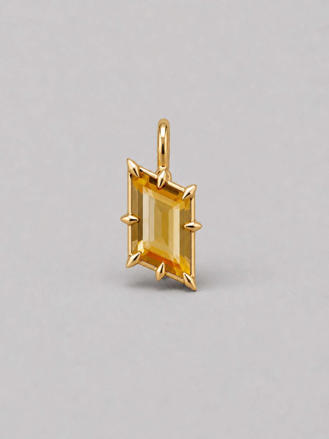 3D render of a gold pendant featuring an rhombus bi-coloured citrine in a multi claw setting, shown on a neutral grey background.