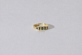 Gold ring with parti sapphires on a light grey background