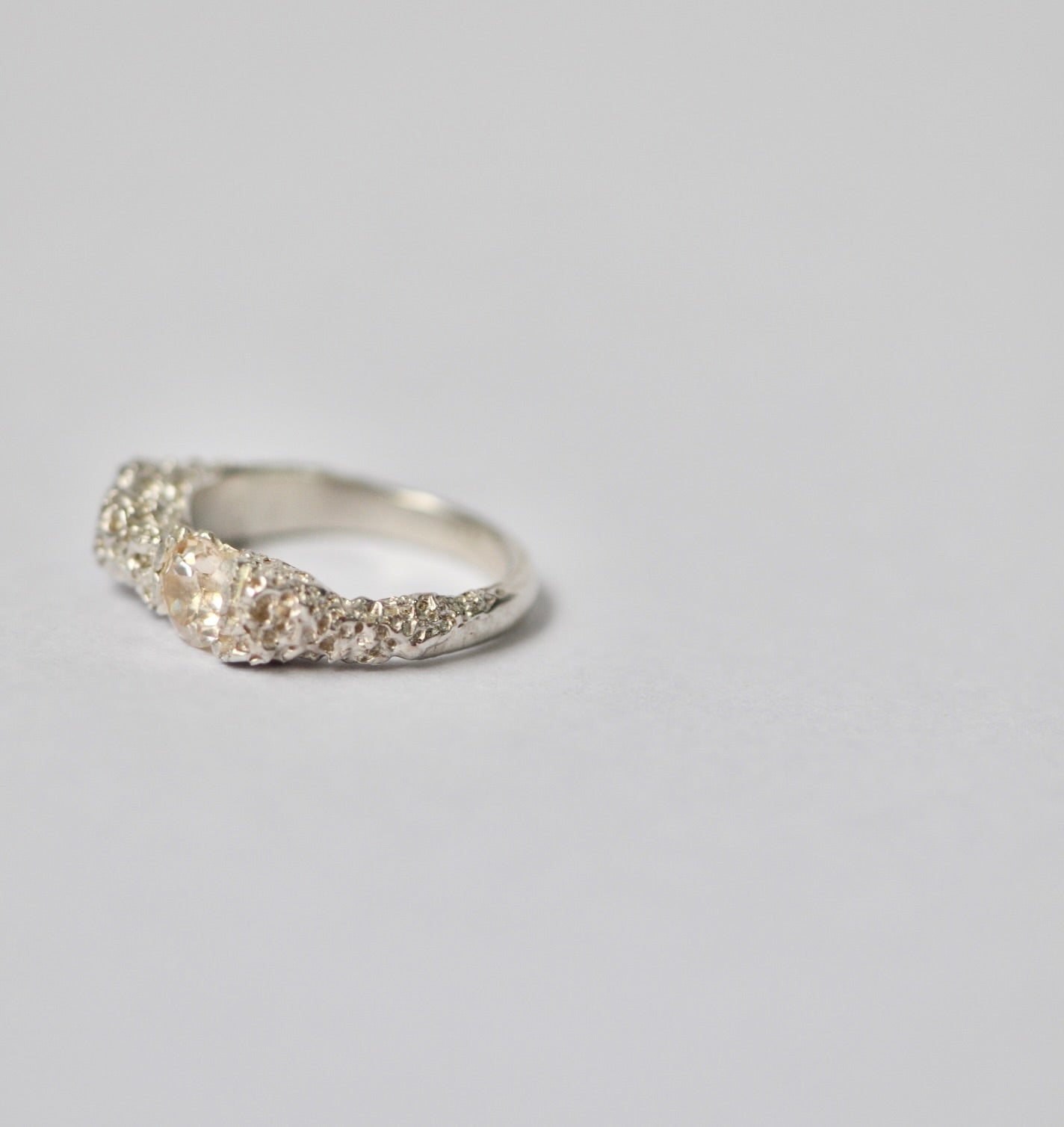 Silver ring with champagne zircon on a light grey background