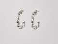 Pair of silver squiggle earrings on a light grey background