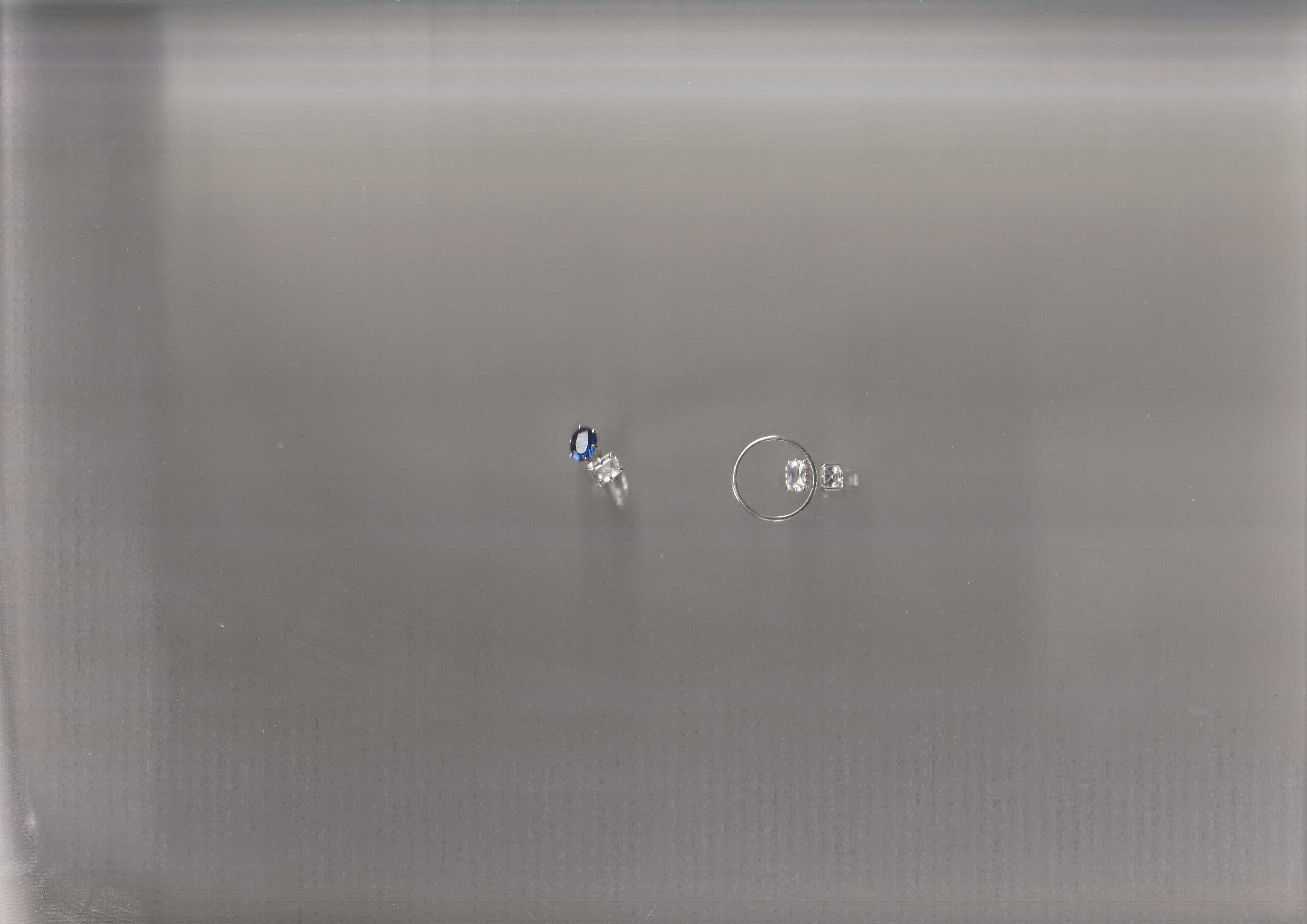 Two diamond and sapphire engagement rings with a soft, scanned-in blur effect