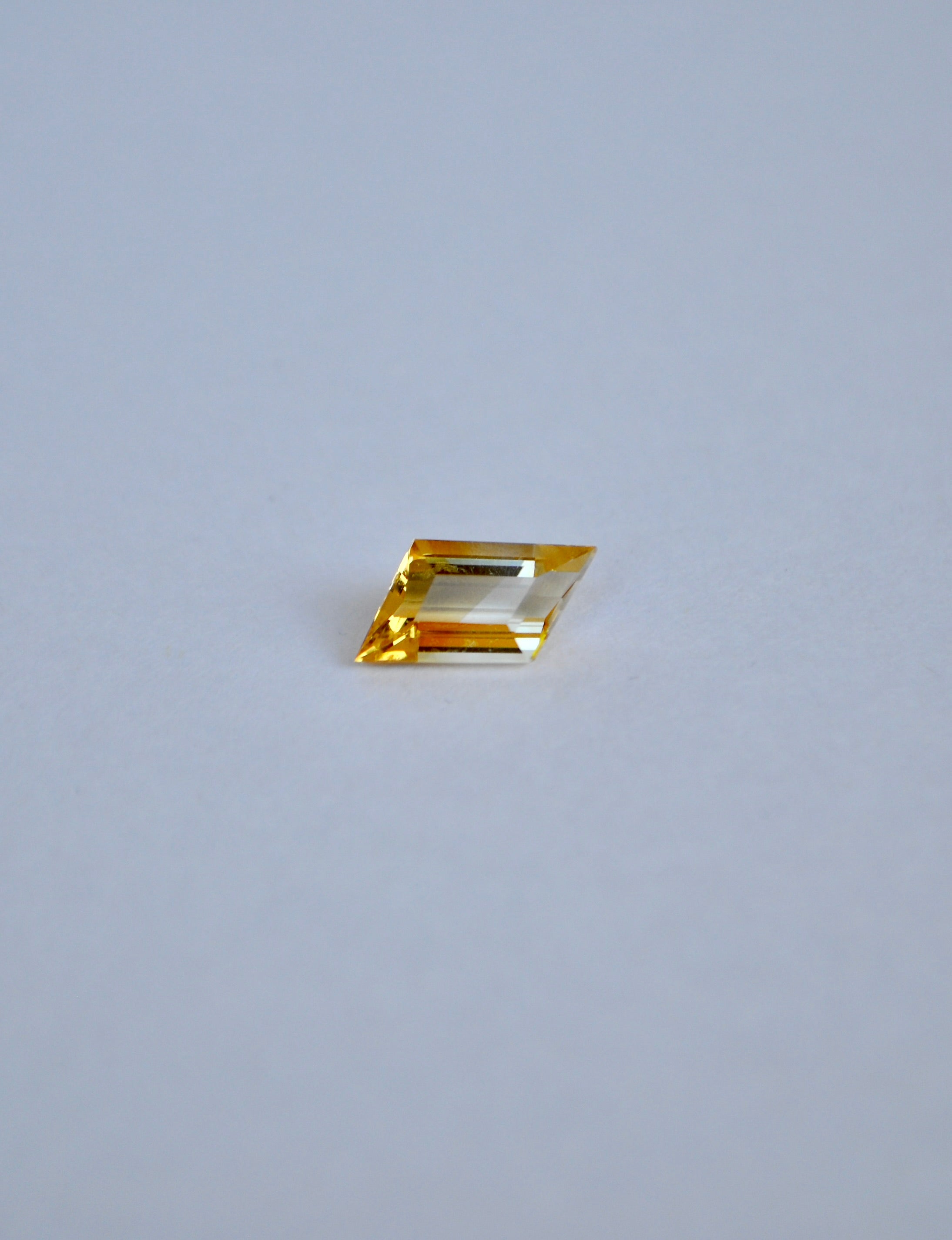 Rhombus bi-colour citrine on a light grey background