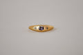 Gold ring with purple sapphire and champagne diamonds on a grey background
