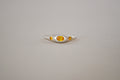 A silver ring featuring a central oval yellow sapphire flanked by two smaller oval yellow sapphire, set against a plain light grey background.