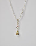 Silver necklace with a teardrop-shaped pendant and yellow sapphire on a light grey background