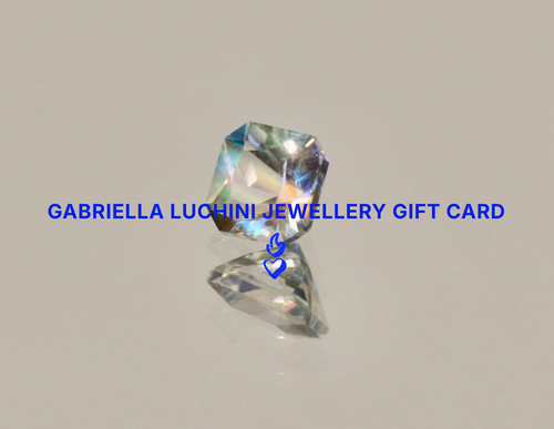 A faceted clear gemstone centered on a light gray background, with blue text reading 'GABRIELLA LUCHINI JEWELLERY GIFT CARD' across the middle and a small blue heart logo below.