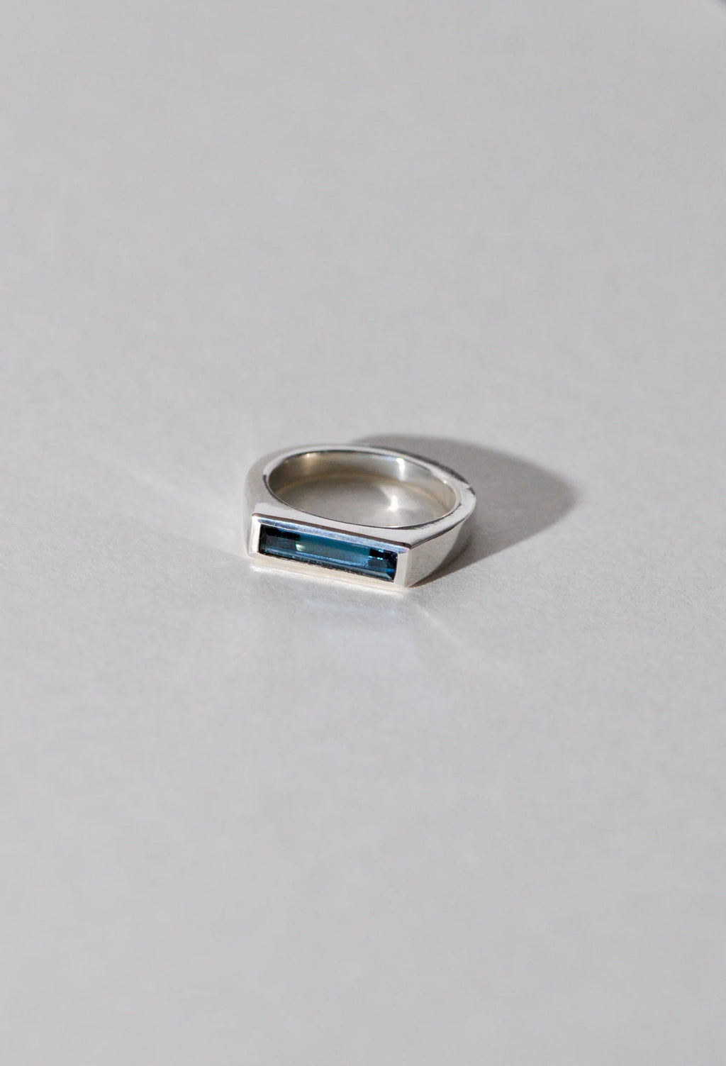 Silver ring with a London blue topaz on a light grey background